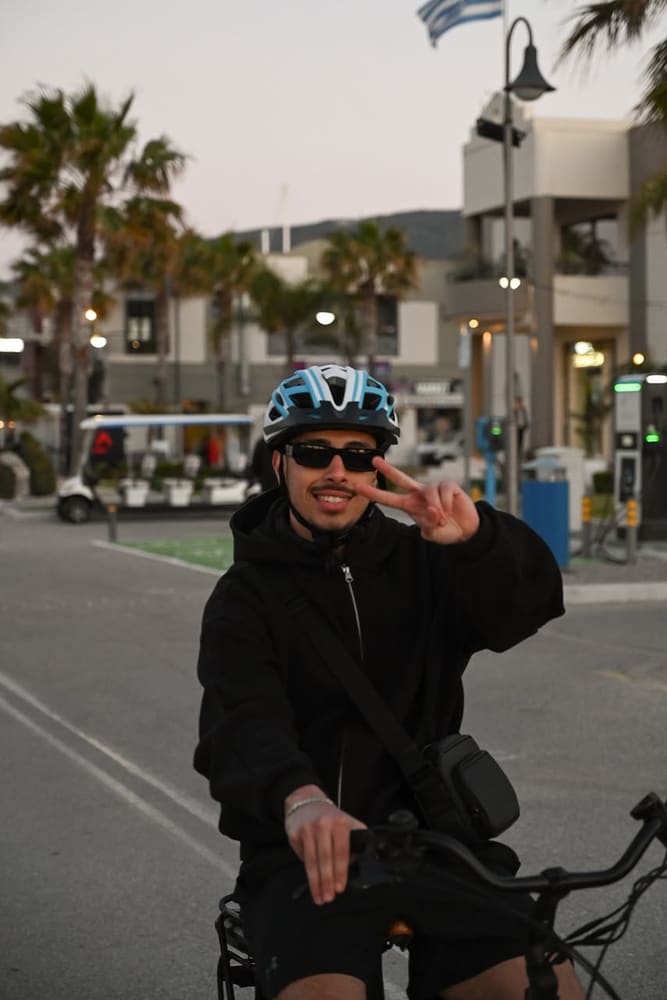 Rider pausing along a flower-lined street