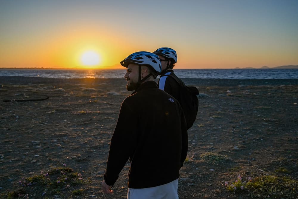 Riders watching the sun set over the sea